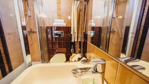 Une salle de bain avec une baignoire, une cabine de douche en verre et des toilettes.