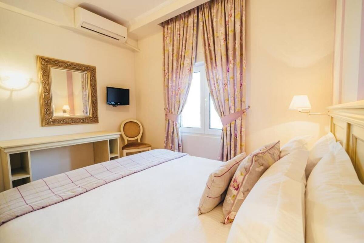 Une chambre d’hôtel avec un lit, une télévision, un bureau et une chaise.