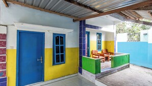 A building with a blue door, a window, and a tiled floor. - Hotel O Kawi Homestay (Praya Barat Daya)