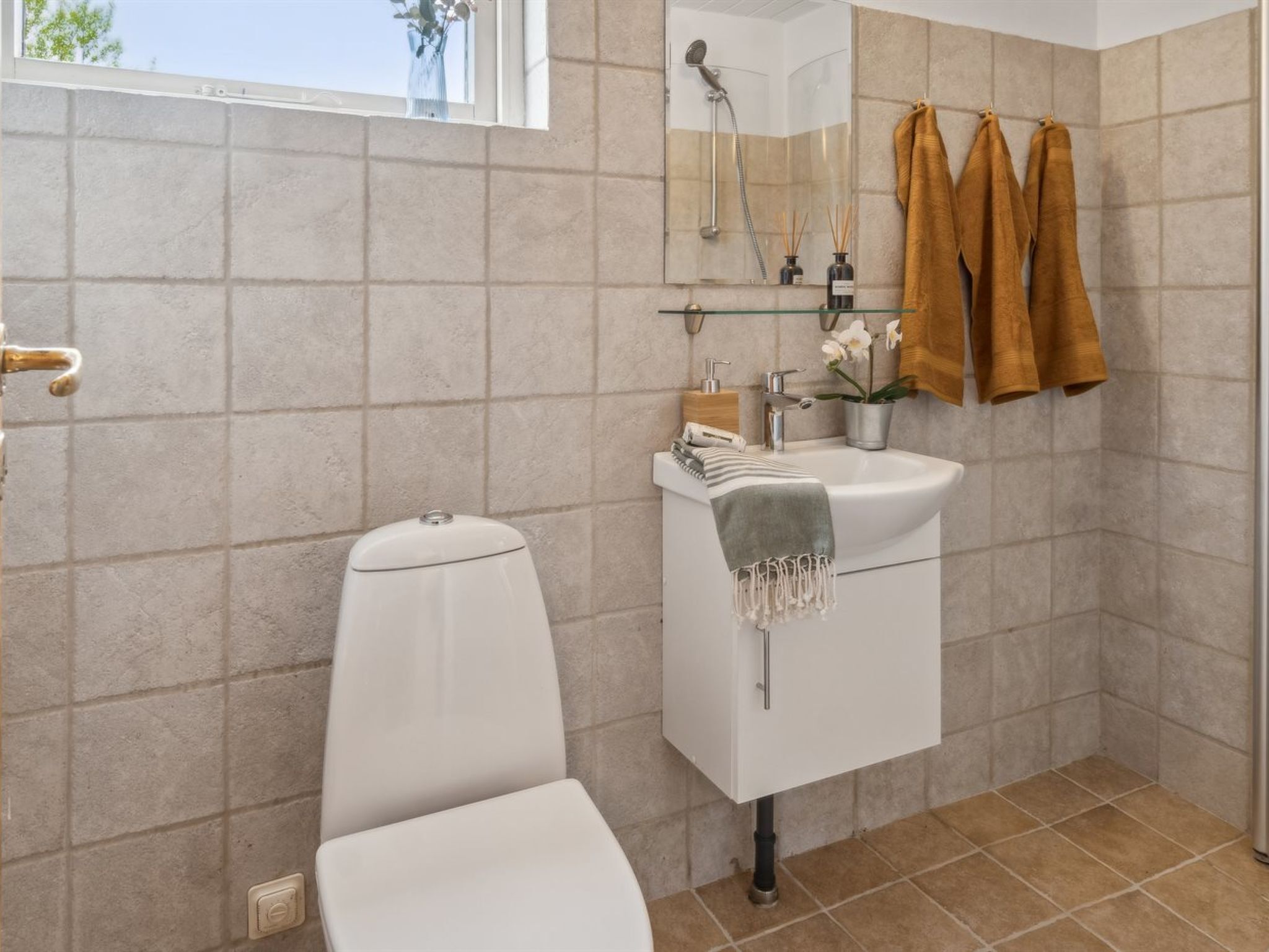 A modern bathroom with a toilet, sink, and shower.