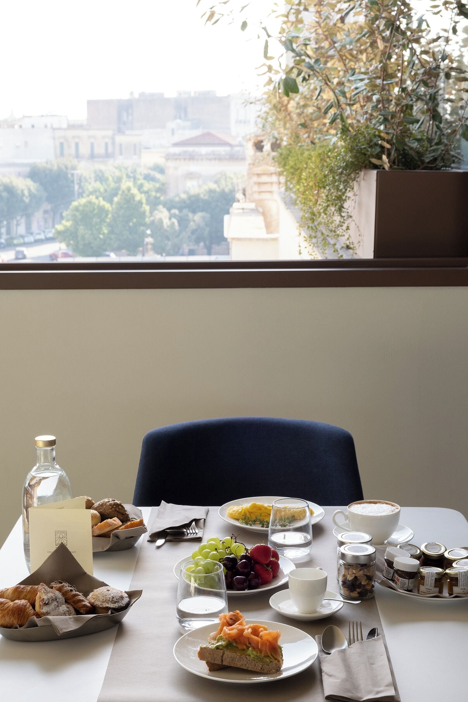 Une table de petit-déjeuner avec divers aliments, une bouteille et un menu.