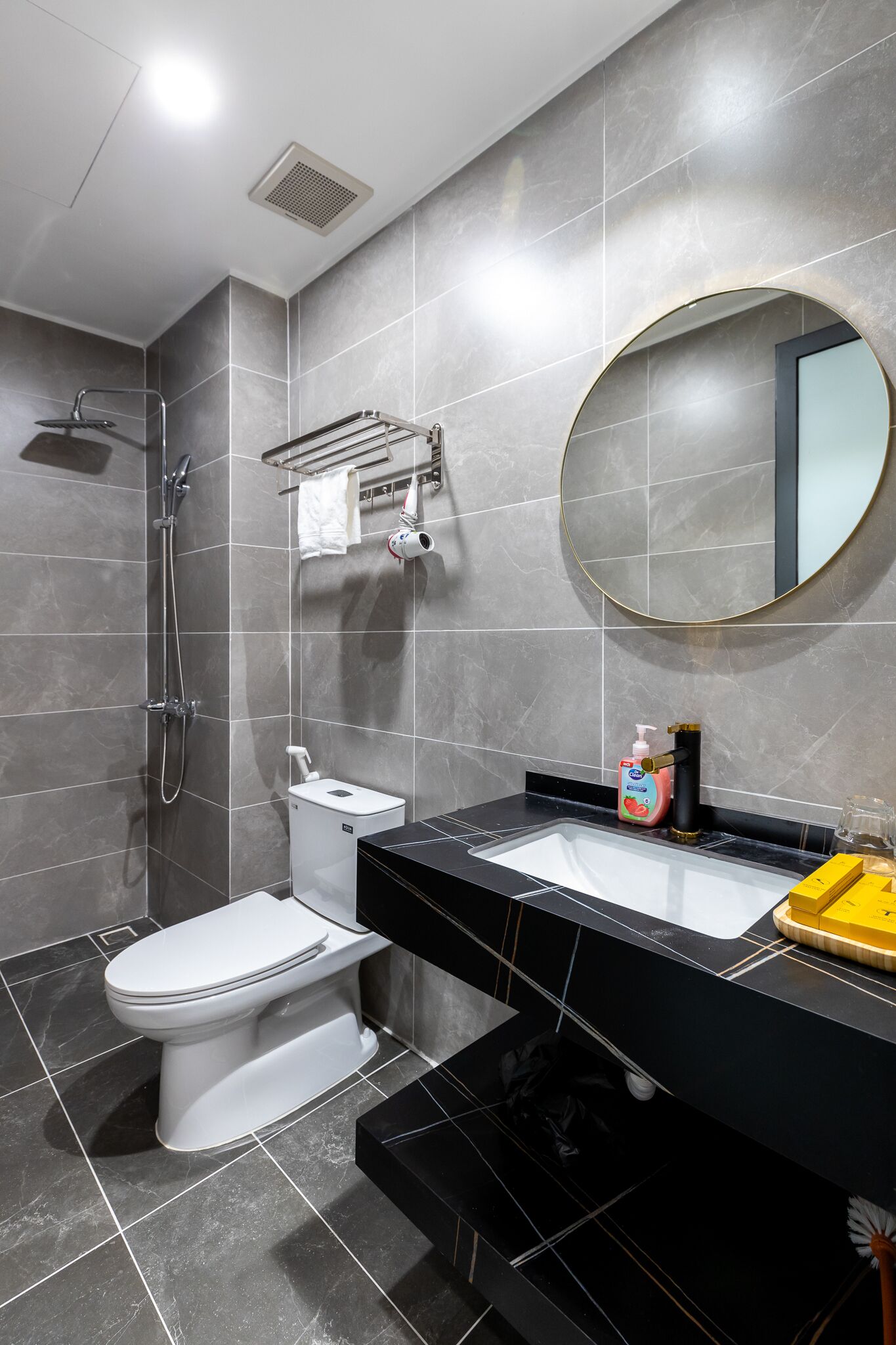 Une salle de bain moderne équipée de toilettes, d’un lavabo et d’une douche.