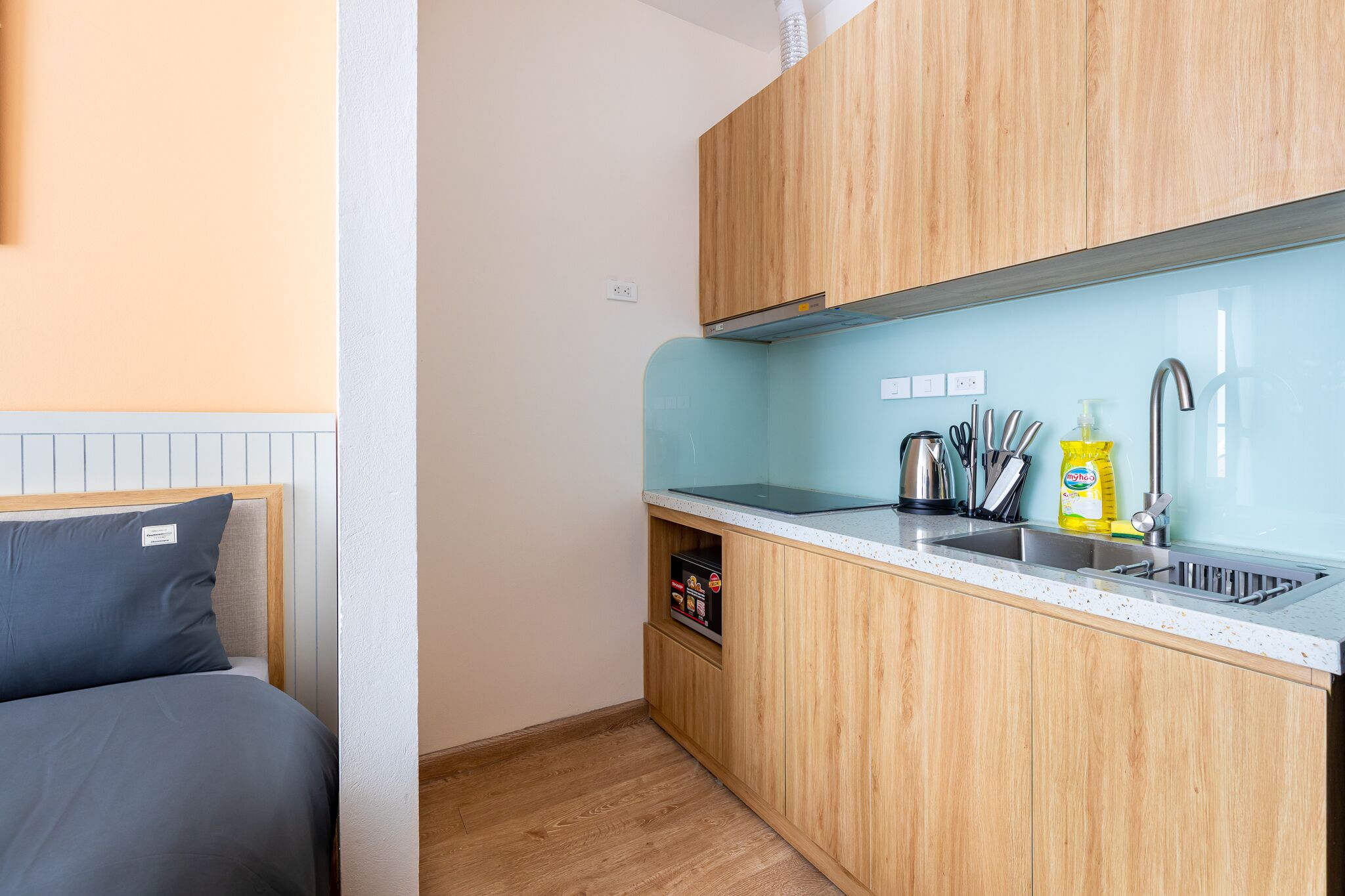 A compact kitchen with wooden cabinets, a stainless steel sink, and a countertop.