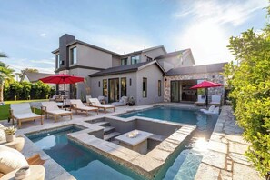 A modern house with a swimming pool, outdoor seating, and a stone facade. - 6 Beds | 5 Showers | Htd. Pool, Firepit & Putt Grn (Scottsdale)