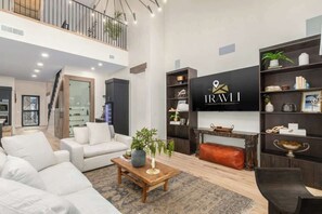 Una sala de estar moderna con sofá, mesa de centro y televisor montado en la pared.