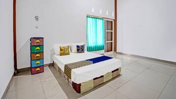 Un dormitorio con cama, armario, ventana con cortinas y suelo de baldosas.