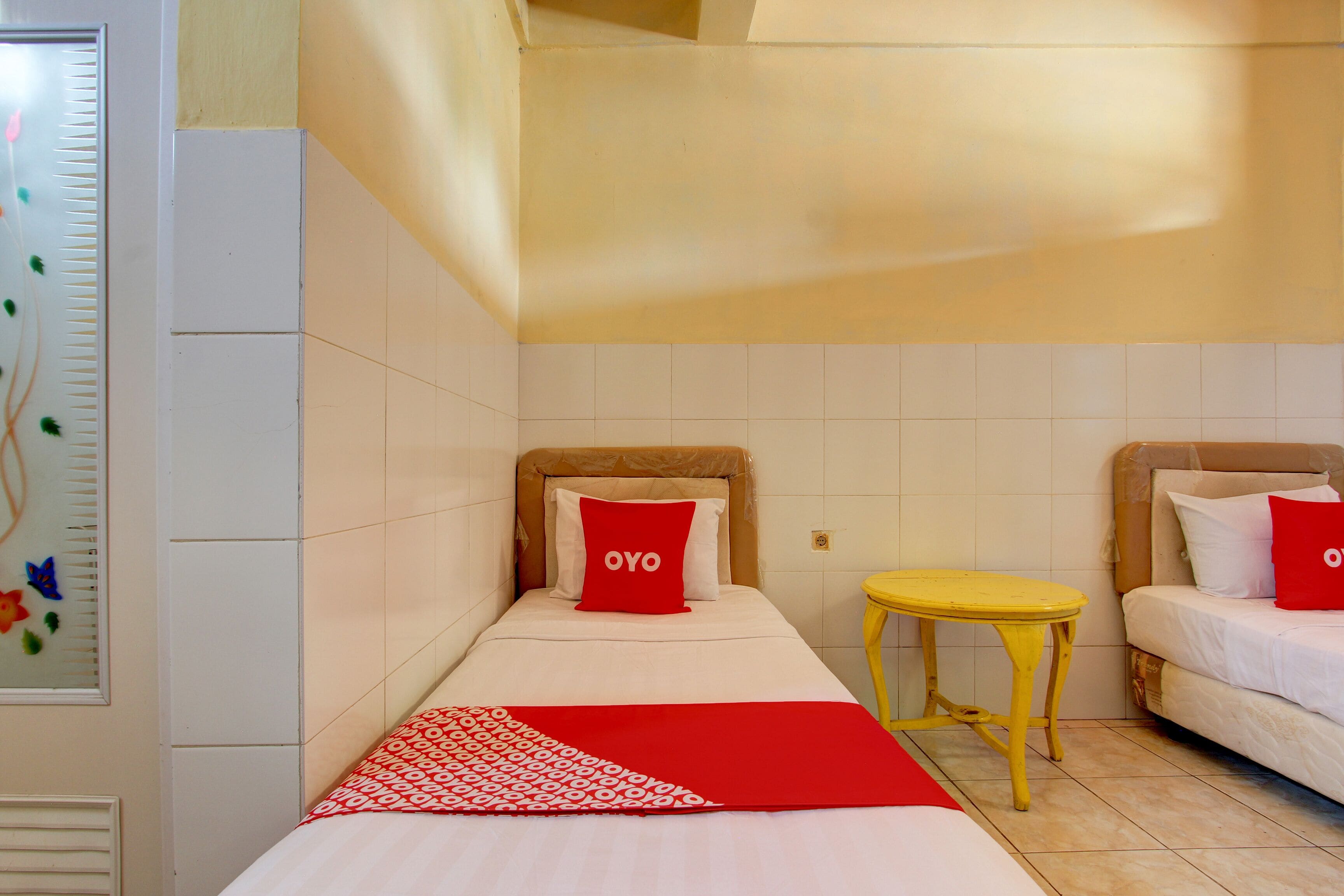 Una habitación de hotel con dos camas, una mesita y una ventana con vistas a la ciudad.