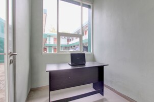 Una habitación con un escritorio y una puerta abierta que da al exterior.