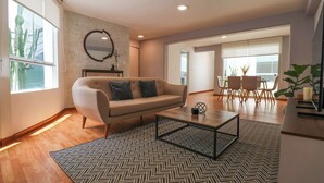 Un salon moderne avec un canapé, une table basse et un coin repas.