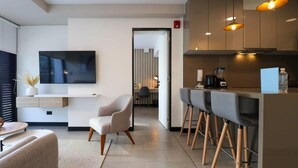 Una cocina moderna con televisión de pantalla plana, taburetes de bar y una isla central.