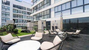 Un edificio moderno con un patio que tiene asientos al aire libre y un área techada.