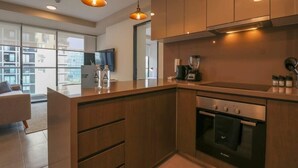 Una cocina moderna con armarios de madera, un horno Bosch e iluminación colgante.
