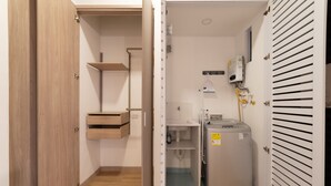A compact bathroom with a toilet, sink, and a small heater unit. - w* | Cozy Loft in Laureles (Medellín)