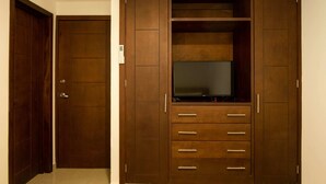 Ein Holzschrank mit Fernsehablage, mehreren Schubladen und einer Tür.