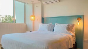 A neatly made bed with white linens, a hanging light fixture, and an air conditioning unit on the wall. - w*| Spectacular 2BR w/ Balcony n AC in Bocagrande (Cartagena de Indias)