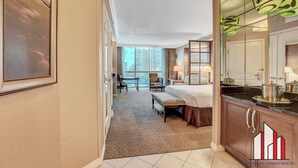 A hotel room with a bed, a desk, a chair, a small table, and a window. - MGM Signature- Group and Family friendly 2 units (Las Vegas)