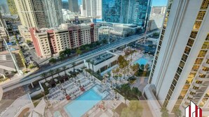 A high-rise building with a rooftop pool and a pedestrian bridge. - MGM Signature- Group and Family friendly 2 units (Las Vegas)