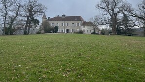 A large, two-story building with a symmetrical facade, multiple windows, and a central entrance. - Grande Maison de Vacances (Projan)