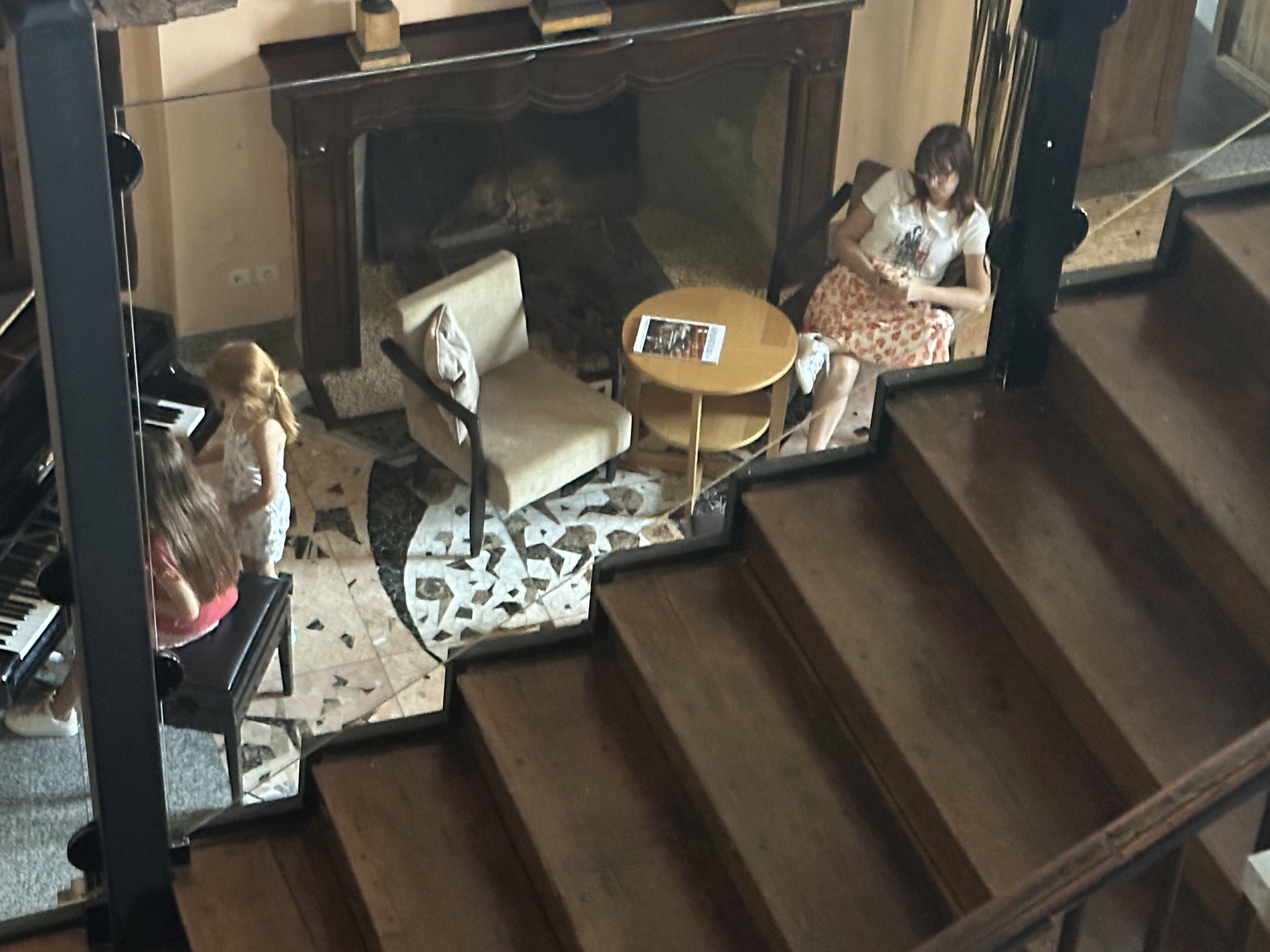 Una habitación con un piano, un sofá, una mesa de centro y una chimenea.