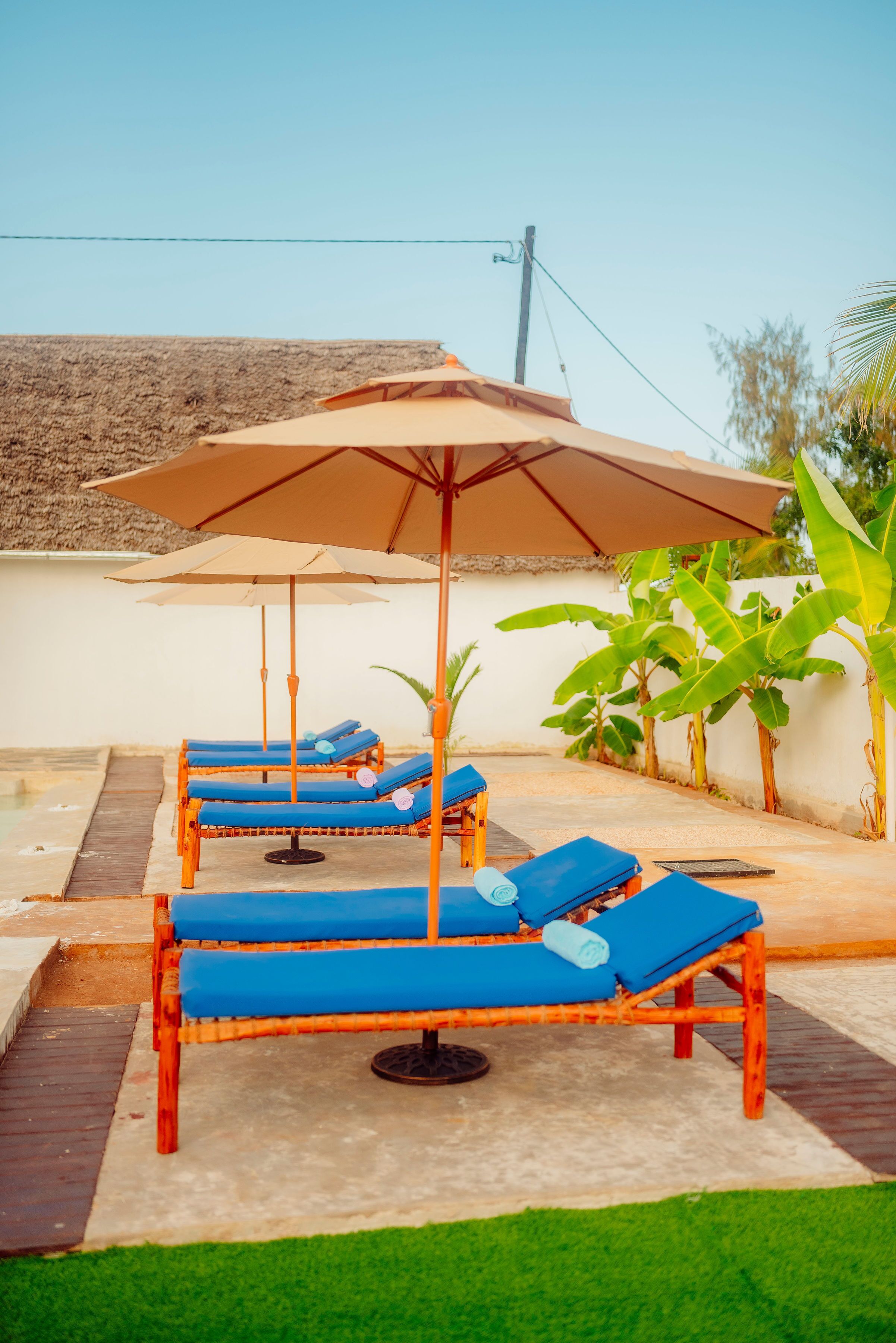 A poolside area with lounge chairs and umbrellas.