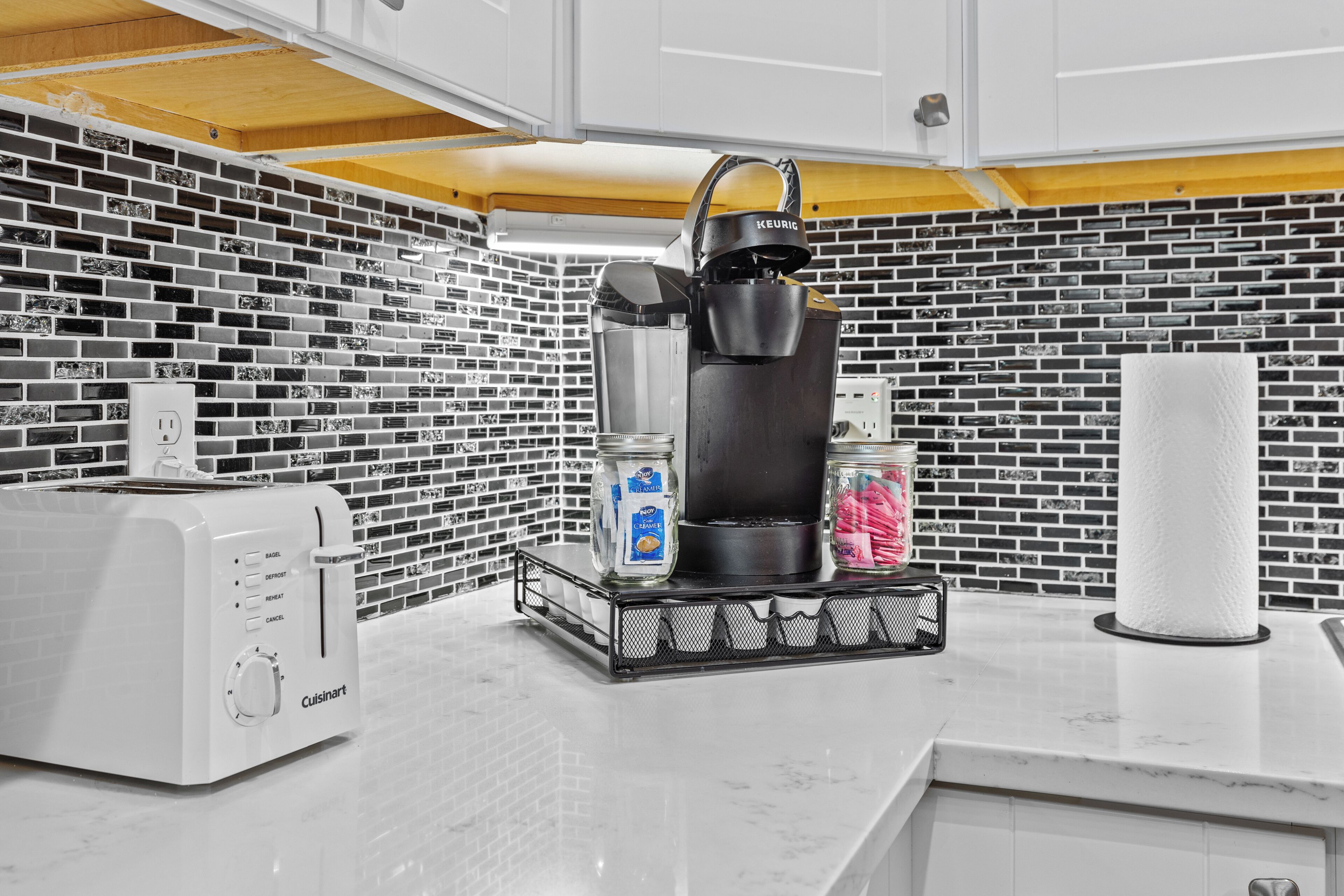 A kitchen with a coffee maker, toaster, and containers on the counter.