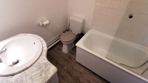 A bathroom with a marble sink, toilet, and bathtub. - Cozy studio at the foot of the slopes with balcony, TV and ski locker (Les Adrets-Prapoutel)