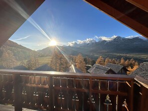 A wooden balcony with a view of a mountain range and a clear sky. - Charming Chalet for 8 with Pool, Terrace, and Mountain Views near Fontettes Lift (La Joue du Loup)