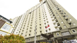 Un immeuble résidentiel de grande hauteur, doté de nombreux balcons et arborant un drapeau.