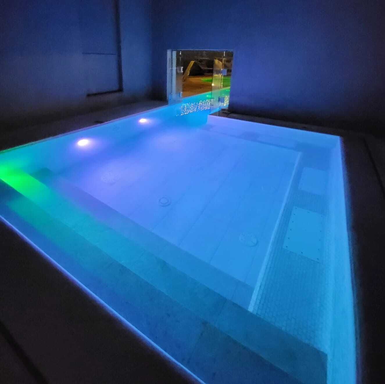 Une pièce dotée d’un grand espace piscine éclairé.