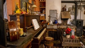 Una habitación con un piano, un radiador y diversos utensilios de cocina.