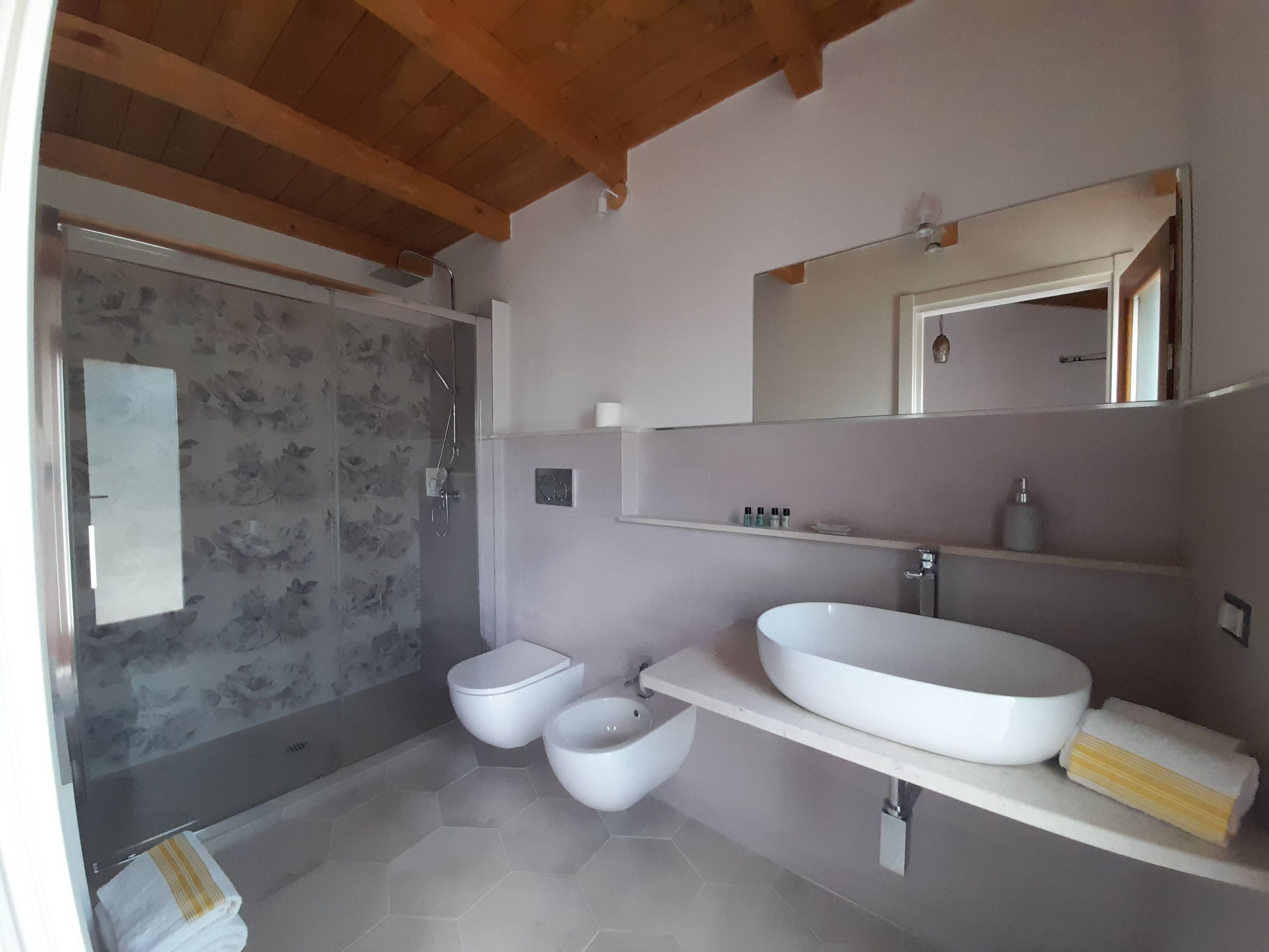 A modern bathroom with a shower, toilet, and sink.