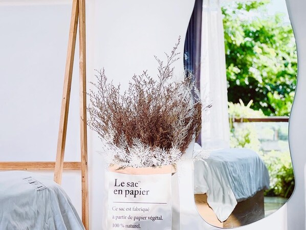 Una habitación con una ventana, un caballete de madera y un cartel que dice 'Le sac en papier'.