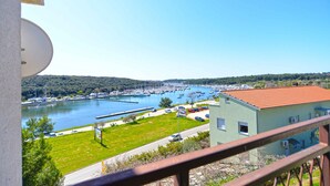 Un port de plaisance avec des bateaux, une zone herbeuse et un bâtiment doté d’un toit rouge.