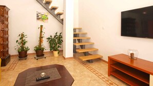 A living room with a staircase, a TV, and a coffee table.