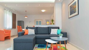 A modern living room with a grey sectional sofa, a small round table, and a colorful rug. - Holiday apartment with air conditioning (Pula)