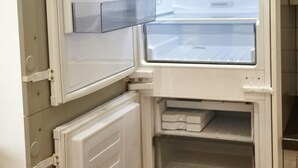 Ein offener Kühlschrank mit mehreren Ablagen und einem Gefrierfach.