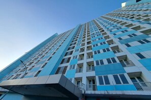 Een hoog gebouw met een modern architectonisch ontwerp, met een raster van ramen en balkons.