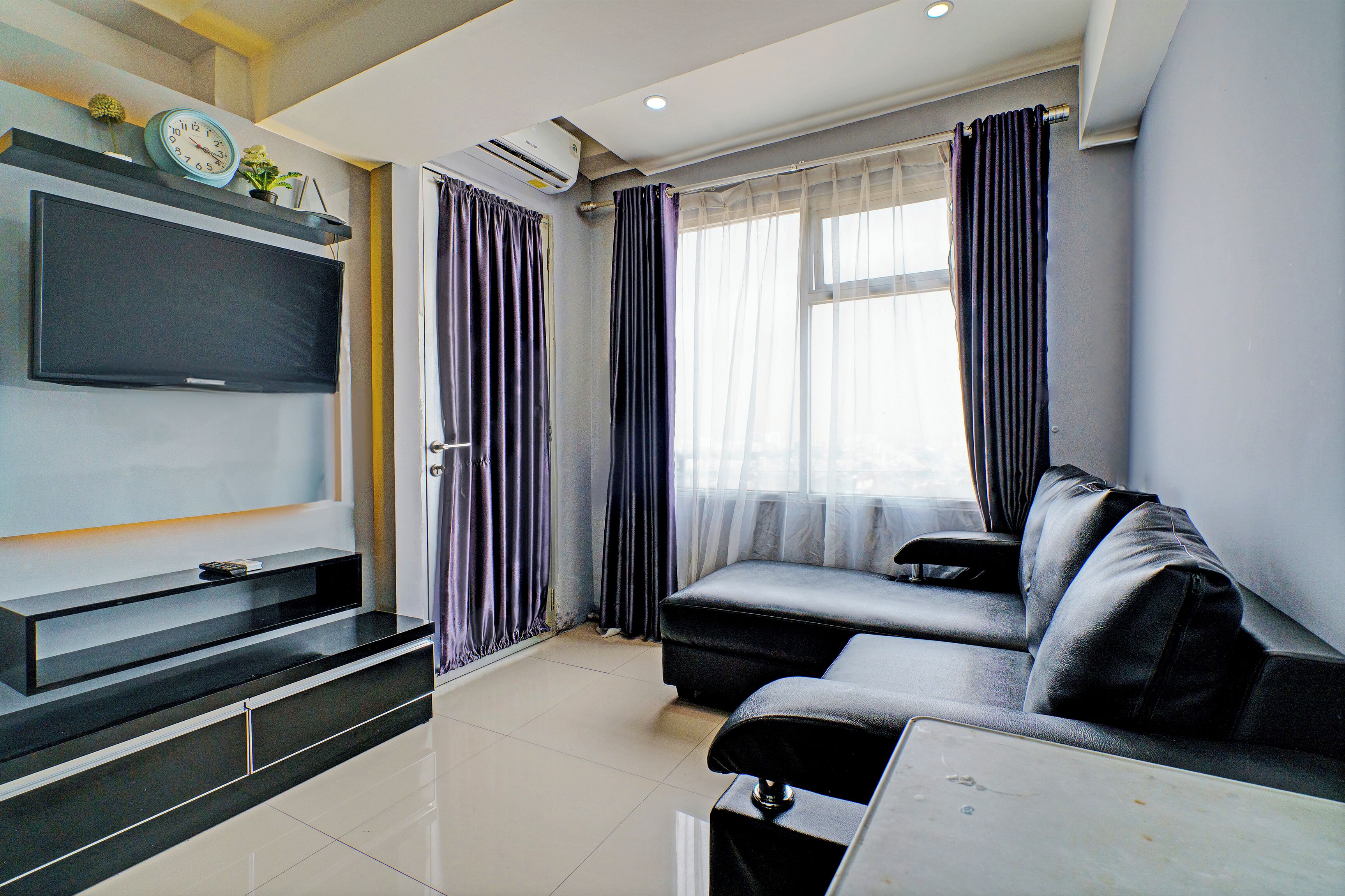 A modern living room with a flat-screen TV, a sofa, and a coffee table.