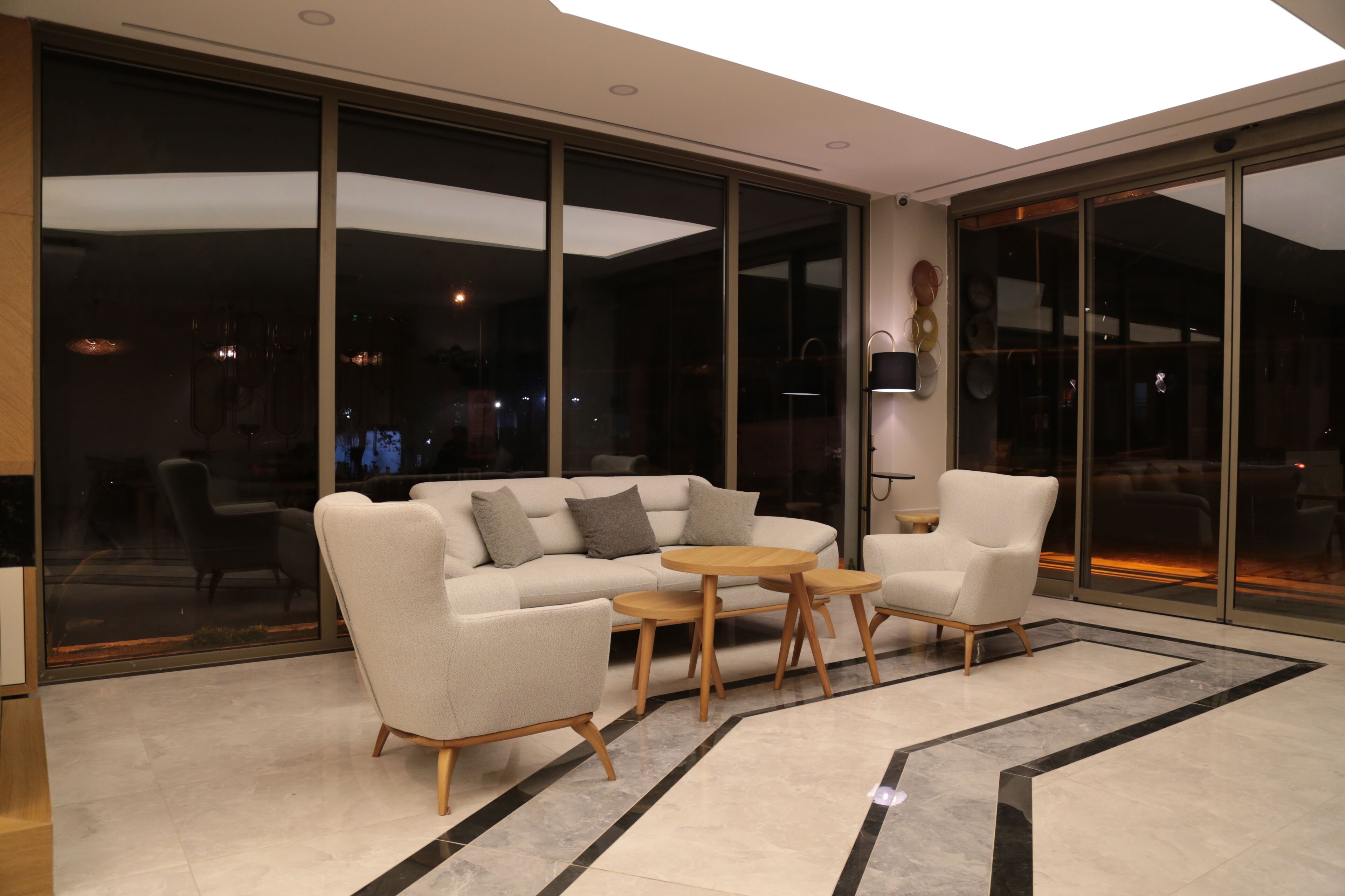 A modern living room with a sofa, armchairs, and a coffee table.