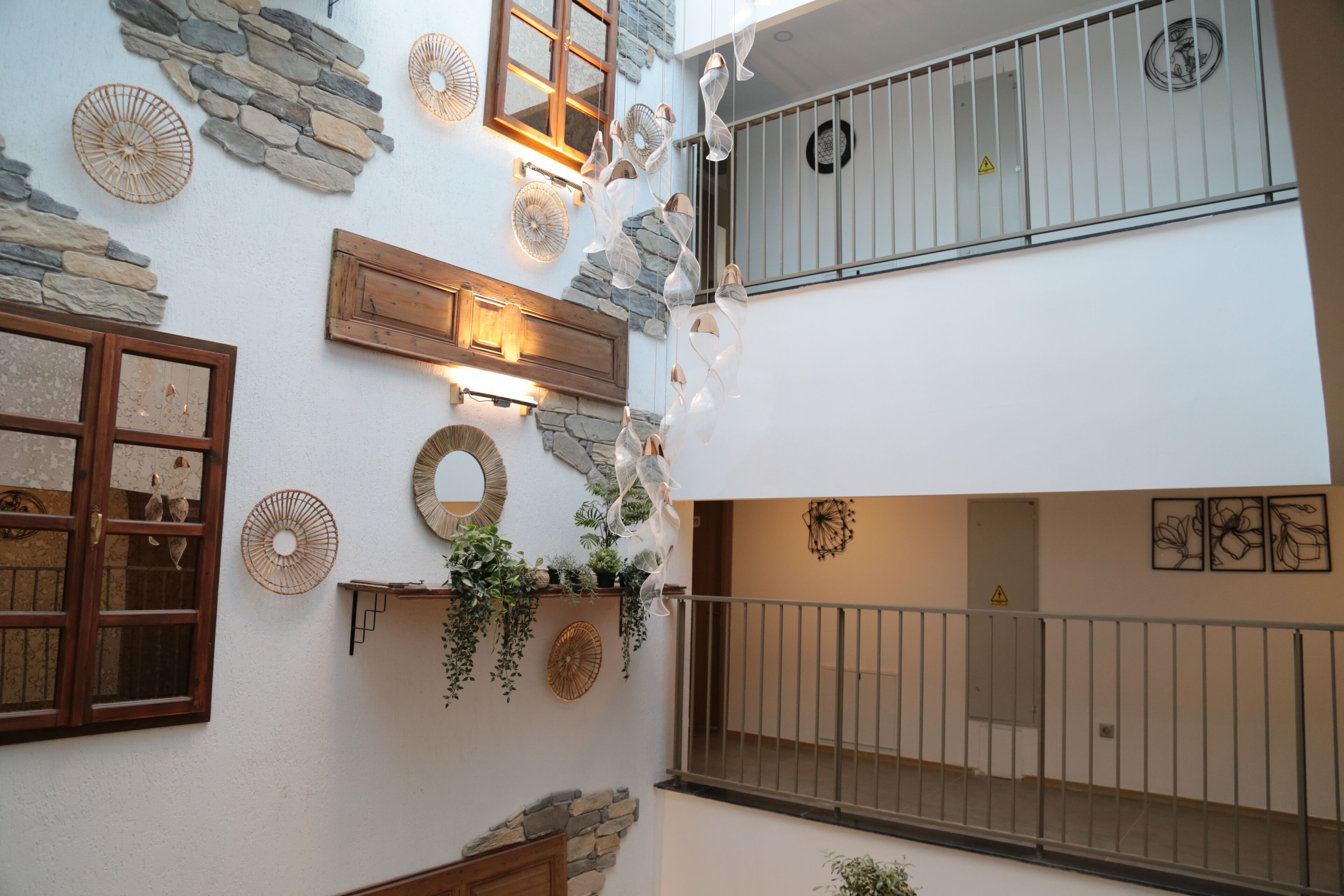 Un intérieur à plusieurs niveaux agrémenté d’éléments en pierre, de poutres en bois et d’un balcon doté de rampes en métal.