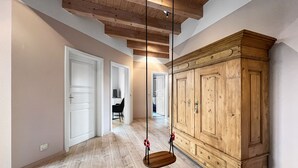 A spacious hallway with wooden floors, a large wooden wardrobe, and a hanging swing. - Kamin Indoorschaukel Smart TV Bose Anlage Ferienhaus Kupferschmiede (Wernigerode)