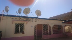 A building with multiple satellite dishes, a barred window, and a "Please No Smoking" sign. - Beautiful 3-bed House in Serrekunda (Serrekunda)