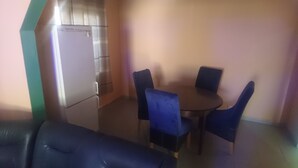 A small dining area with a table and four chairs, a refrigerator, and a sofa. - Beautiful 3-bed House in Serrekunda (Serrekunda)