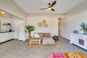 A modern living room with a sofa, a coffee table, and a ceiling fan.