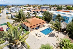 Un resort con piscina, palmeras y vista al océano.
