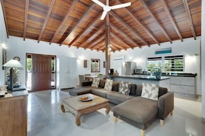 A spacious living area with a high ceiling, a central ceiling fan, and a kitchen area with a modern design. - Salinja Breeze with pool and salt lake view (Kralendijk)
