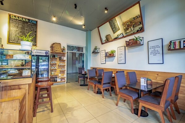 A cafe with wooden furniture, a menu board, and a mirror on the wall.