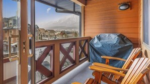 Une terrasse en bois offrant une vue sur la montagne et la ville.