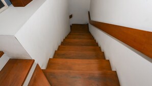 A staircase with wooden steps and white walls. - OYO 93370 Lot Thirty Six (Bekasi)