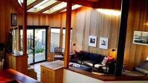 Un interior de madera con un sofá, una mesita de centro y un televisor.